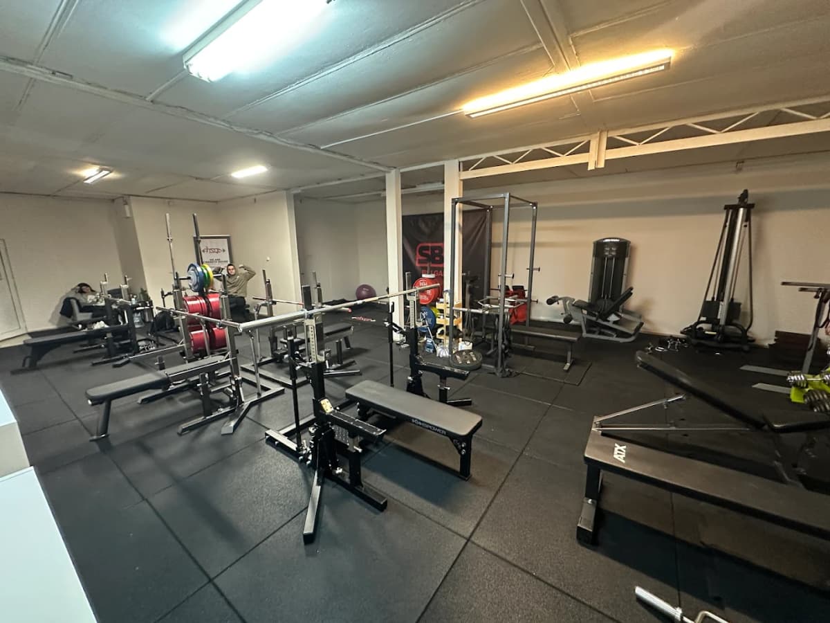 Strength Squad HQ — цялостен изглед на залата с стелажи и пейки